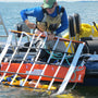 Load image into Gallery viewer, MOB rescue cradle being used for man overboard recovery by a rescuer on a boat in the water.
